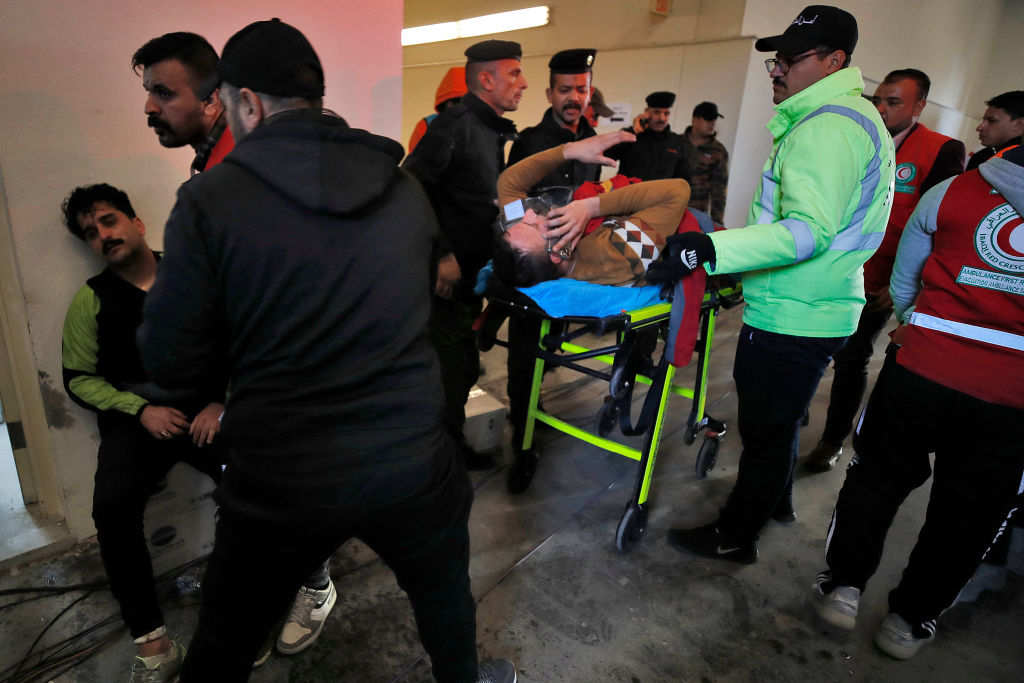 Injured football spectators are brought into an emergency area at the Basra International Stadium following a stampede ahead of this evening's final match of the Arabian Gulf Cup between Iraq and Oman, on January 19, 2023 in Basra. - One person was killed and dozens injured when a stampede broke out outside the football stadium in southern Iraq hours before the Gulf Cup final, medical and security sources said. (Photo by AHMAD AL-RUBAYE / AFP) (Photo by AHMAD AL-RUBAYE/AFP via Getty Images)
