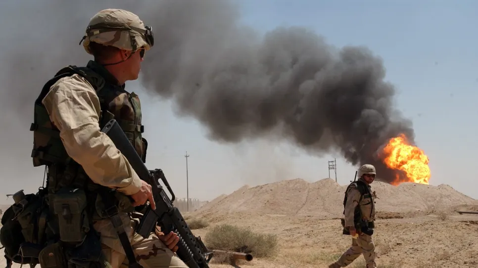 US_Navy_030402-N-5362A-004_U.S._Army_Sgt._Mark_Phiffer_stands_guard_duty_near_a_burning_oil_well_in_the_Rumaylah_Oil_Fields_in_Southern_Iraq.jpg